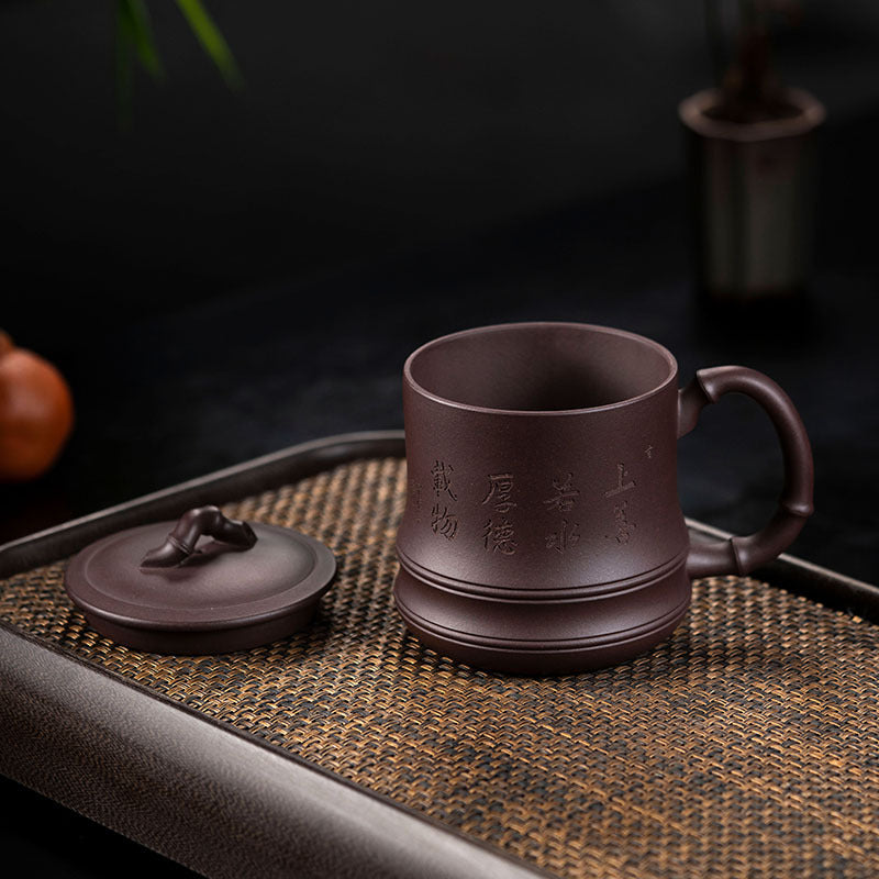 Handmade Yixing purple sand cup with lid on a tray, showcasing original craftsmanship and detailed traditional design.