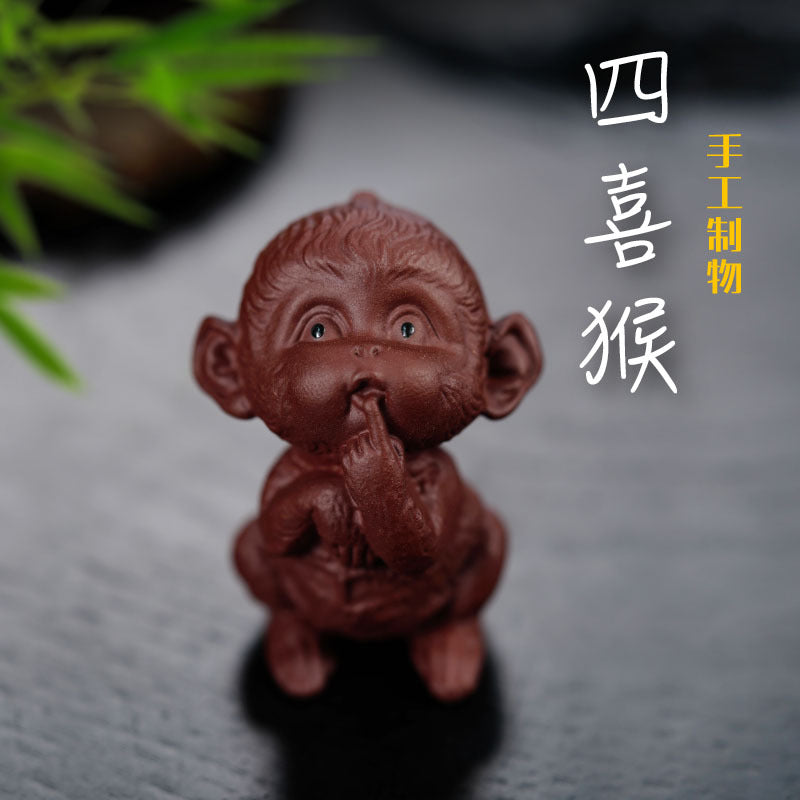Handmade Yixing purple sand monkey sculpture for tea table decor, showcasing craftsmanship and artistry.