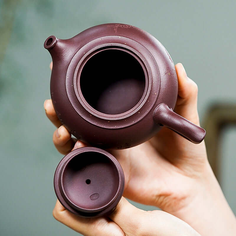 Handmade Yixing purple sand teapot with a rich dark hue, showcasing its elegant design and craftsmanship.
