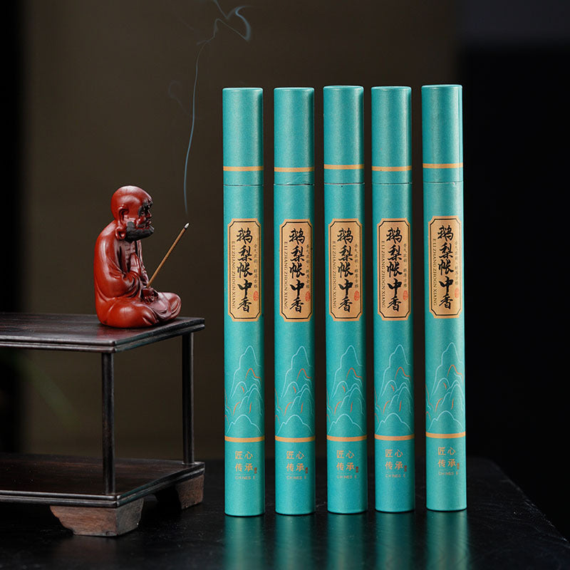 Handmade Yixing purple sand tea pet sculpture with incense, alongside green tea books, showcasing exquisite craftsmanship.