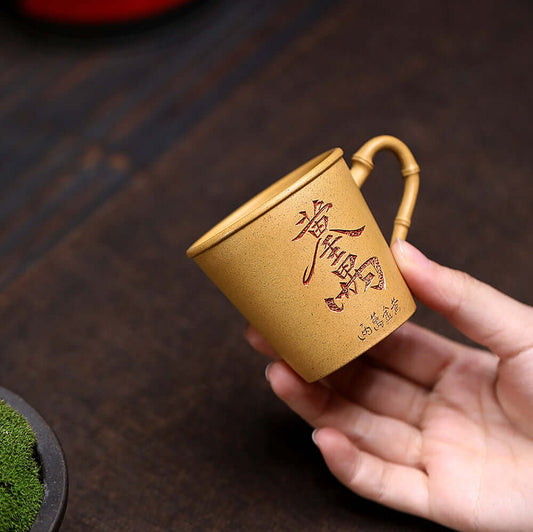 Handmade Yixing purple sand tea cup with bamboo handle, perfect for kung fu tea set, showcasing original craftsmanship.