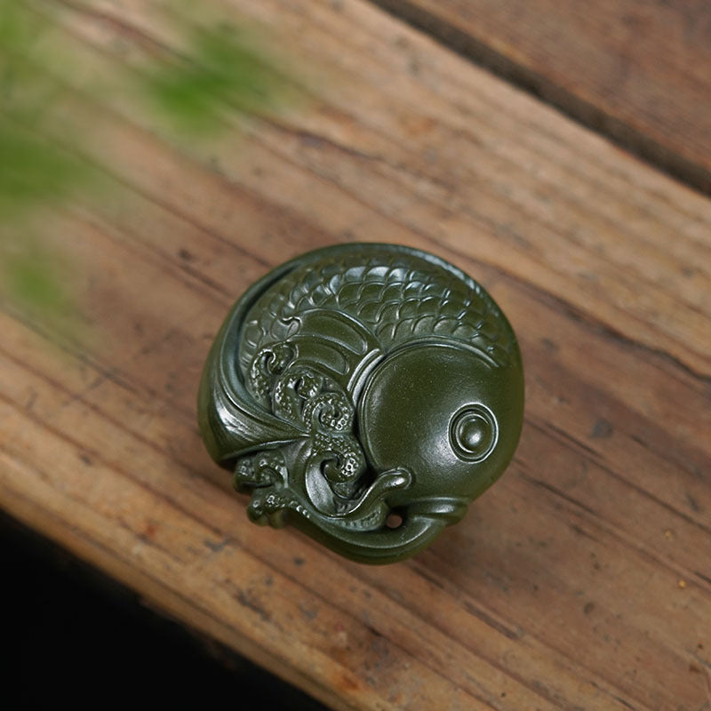 Handmade Yixing purple sand tea pet ornament in green mud, featuring intricate fish sculpture for tea table decoration.