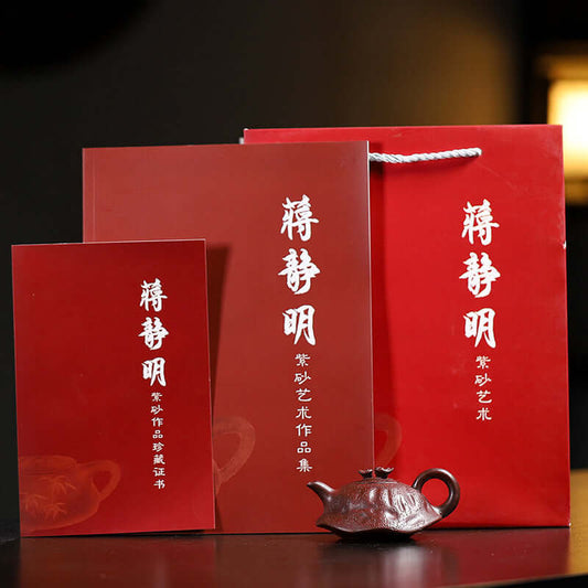 Handmade Yixing purple sand teapot packaging with artist certification and instruction booklets, traditional craftsmanship.