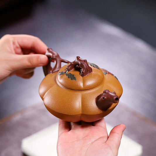 Handmade Yixing purple sand teapot shaped like a pumpkin, elegantly designed with intricate details.