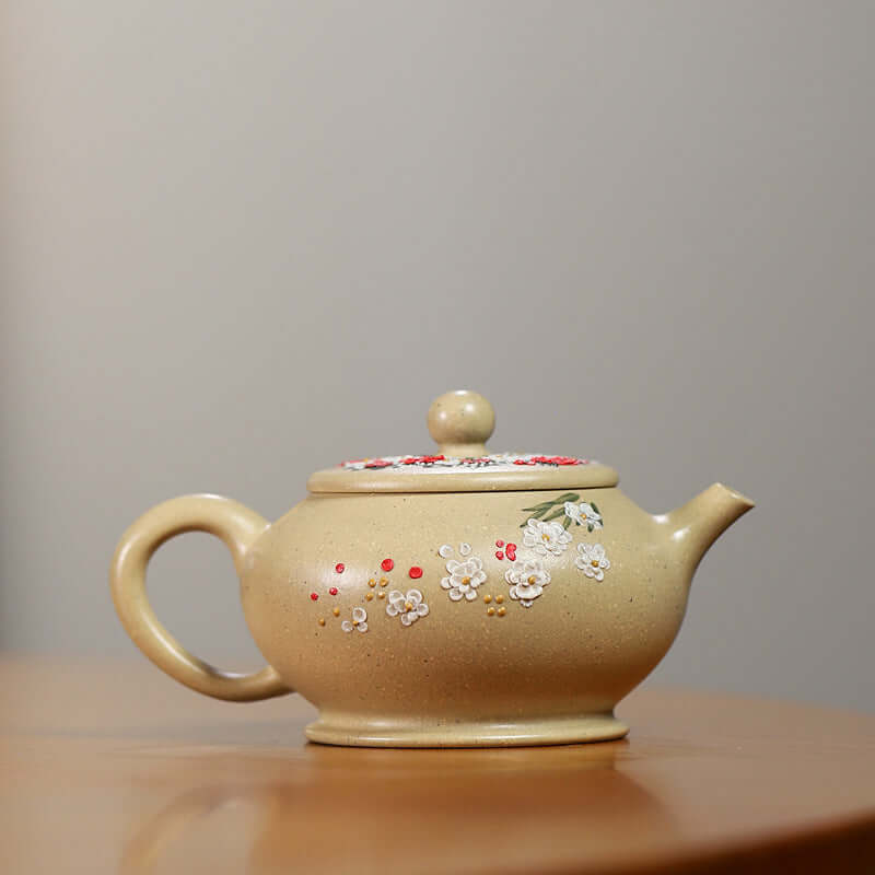 Handmade Yixing purple sand teapot with floral decoration and rounded shape, perfect for tea enthusiasts.