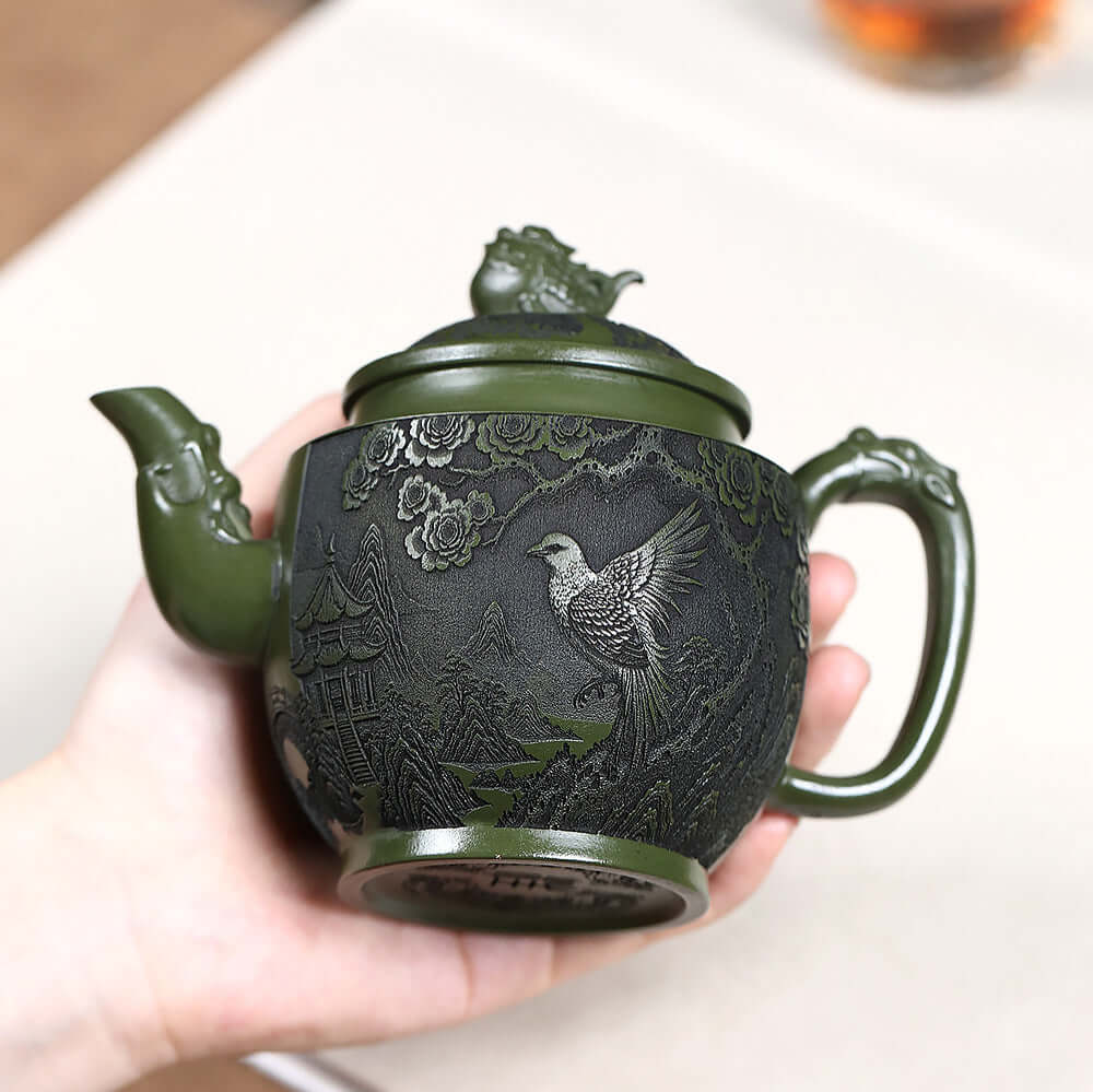 Handmade Yixing purple sand teapot with green clay carving of a bird and flowers, ideal for Kung Fu tea ceremonies.