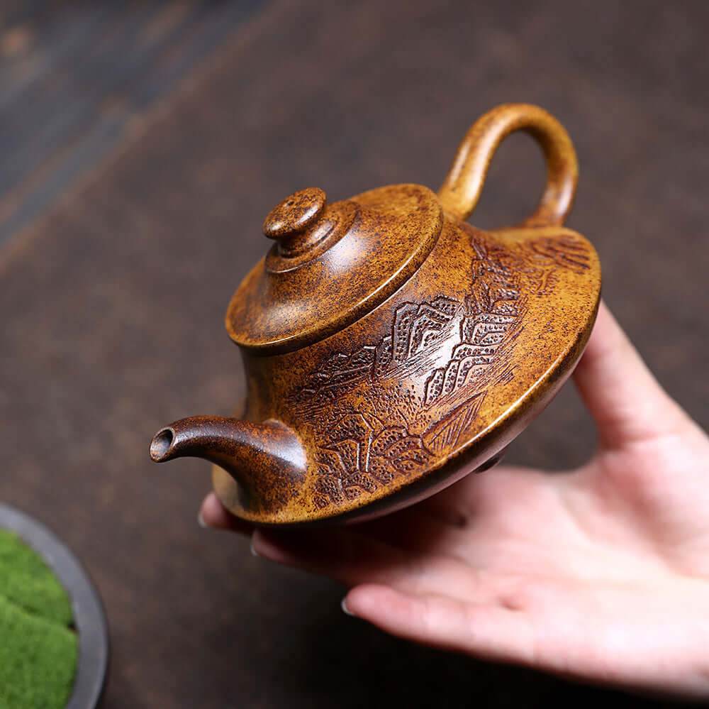 Handmade Yixing purple sand teapot with intricate mountain designs, perfect for traditional kung fu tea sets.