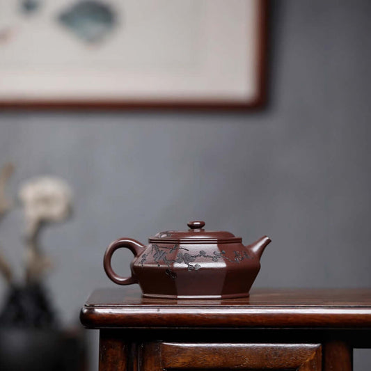 Handmade Yixing purple sand teapot with plum blossom engraving, perfect for tea enthusiasts and collectors.