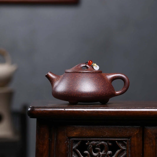 Handmade Yixing purple sand teapot with intricate design, ideal for Kung Fu tea ceremonies in a classic setting.