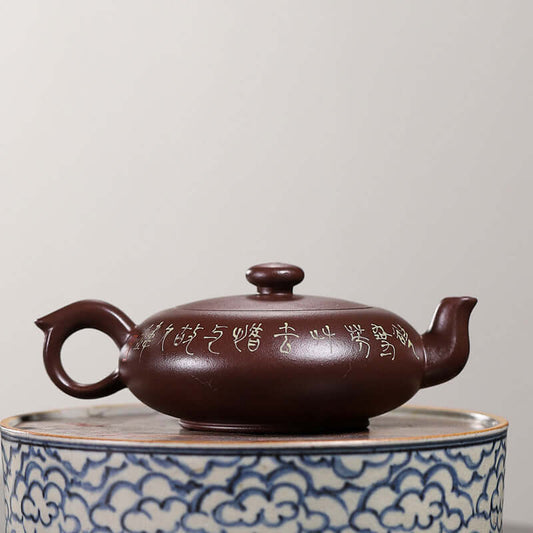 Handmade Yixing purple sand teapot with intricate inscriptions, showcasing unique craftsmanship and traditional design.
