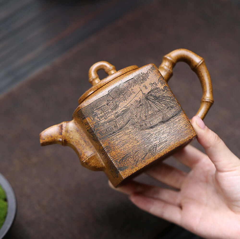 Handmade Yixing purple sand teapot with bamboo handle and intricate design, perfect for kung fu tea sets.