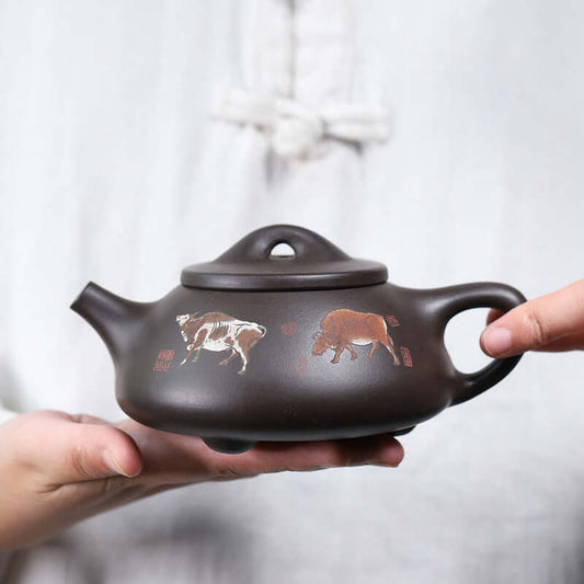 Handmade Yixing purple sand teapot featuring cow paintings, perfect for kung fu tea ceremonies.