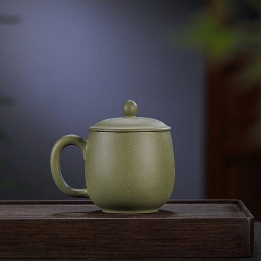 Handmade Yixing purple sand tea cup in bean green color, featuring a tip cover and crafted by skilled artisans.