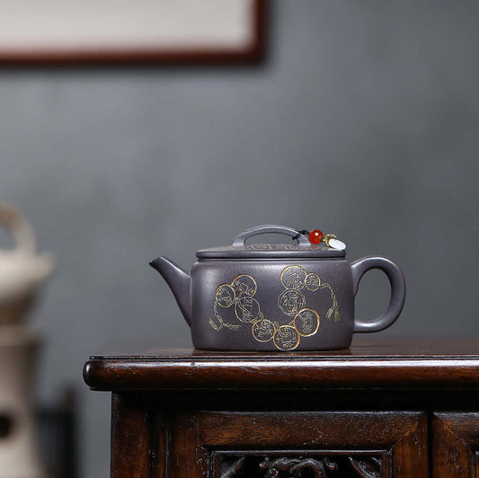 Handmade Yixing purple sand teapot with intricate gold designs, ideal for Kung Fu tea sets and elegant home decor.