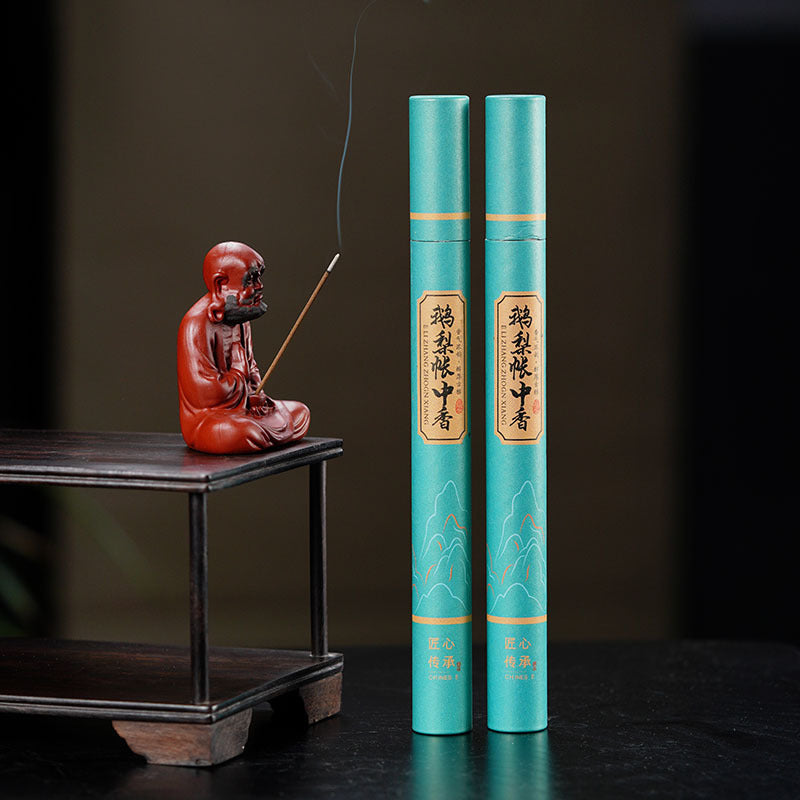 Handmade Yixing purple sand tea pet incense holder with two incense sticks on a wooden stand.