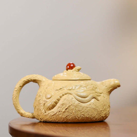 Handmade Yixing purple sand teapot with dragon design and red handle, elegant craftsmanship for tea enthusiasts.