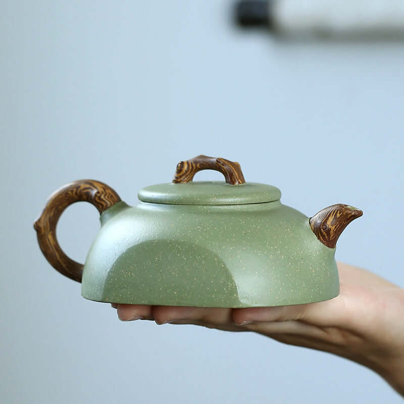 Handmade Yixing purple sand teapot with twisted clay handle, elegant green finish, perfect for tea lovers.