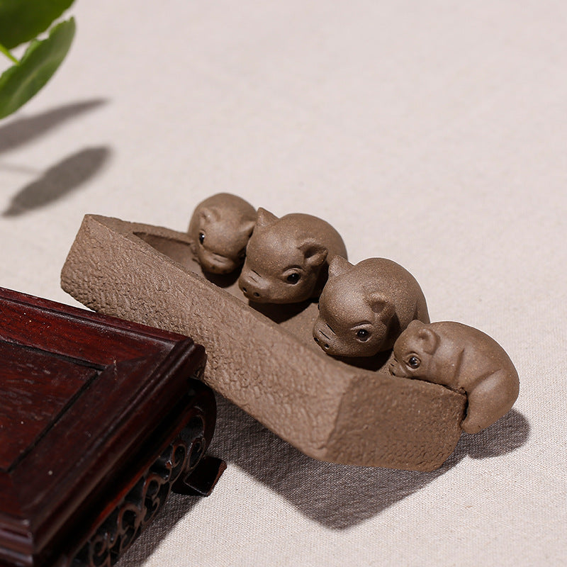 Handmade Yixing purple sand tea pet featuring four piglet ornaments, ideal for tea ceremonies and decorative displays.