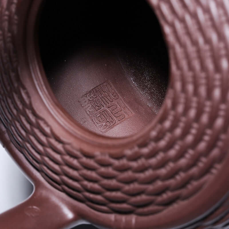 Interior view of handmade Yixing purple sand teapot showcasing intricate clay craftsmanship and signature detail.