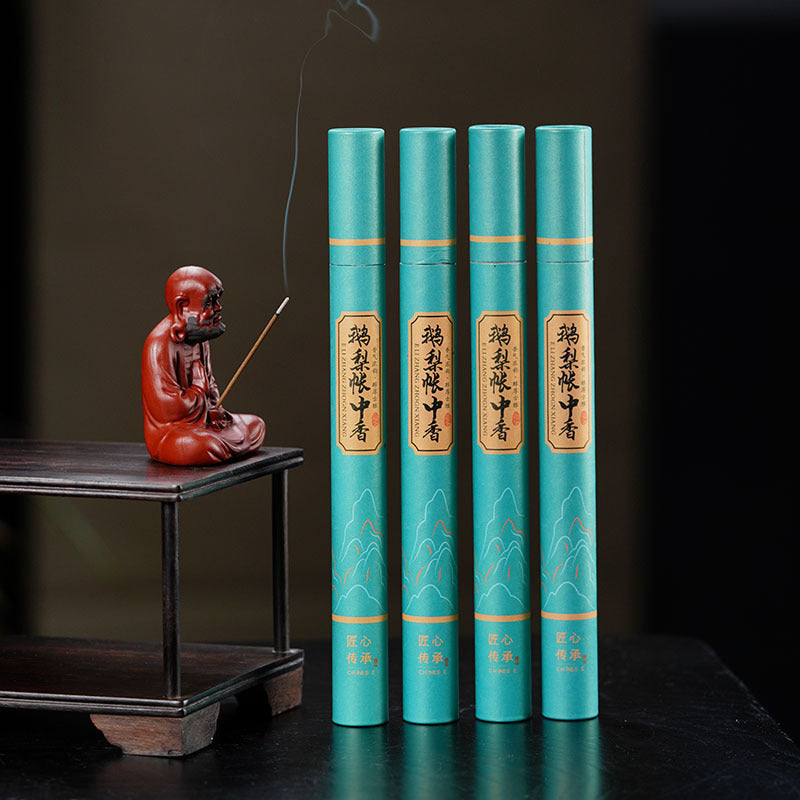Handmade Yixing purple sand tea pet sculpture with incense on a wooden stand and decorative tea packaging.