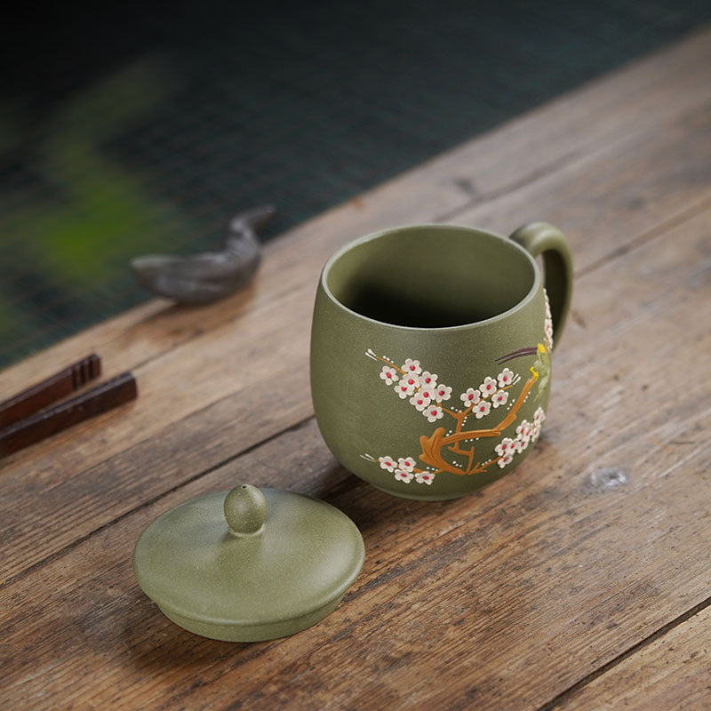 Handmade Yixing purple sand tea cup with floral design, elegant green color, crafted by expert artisans.