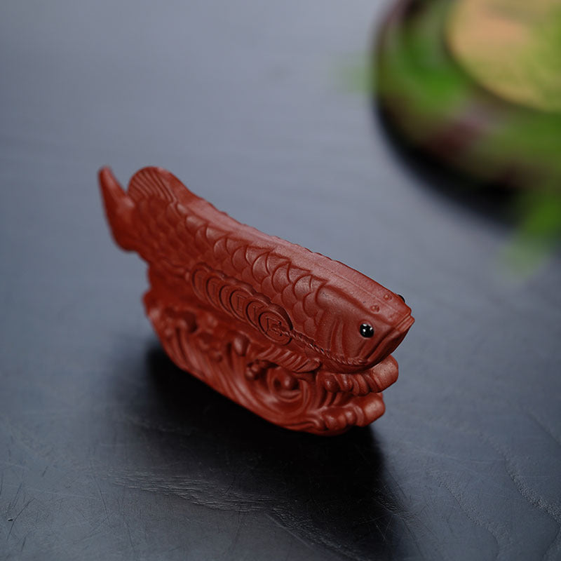 Handmade Yixing purple sand tea pet ornament featuring a golden dragon fish sculpture.