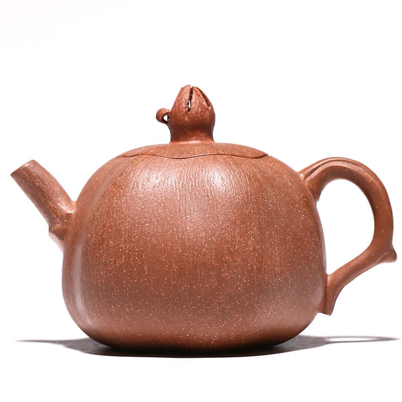 Handmade Yixing purple sand teapot with pomegranate design, showcasing unique craftsmanship and rich texture.