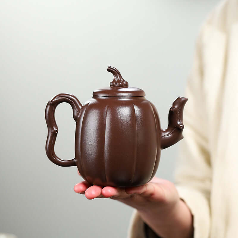 Handmade Yixing purple sand teapot shaped like a melon, showcasing fine craftsmanship and traditional design.