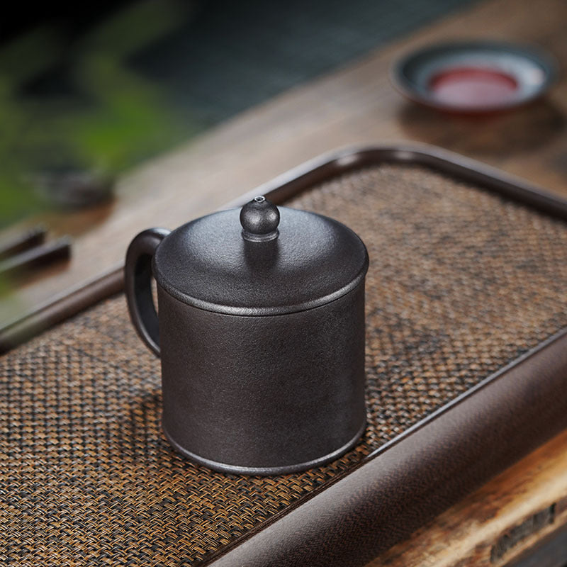 Handmade Yixing purple sand teapot on a bamboo tea tray, featuring a sleek design for elegant tea service.