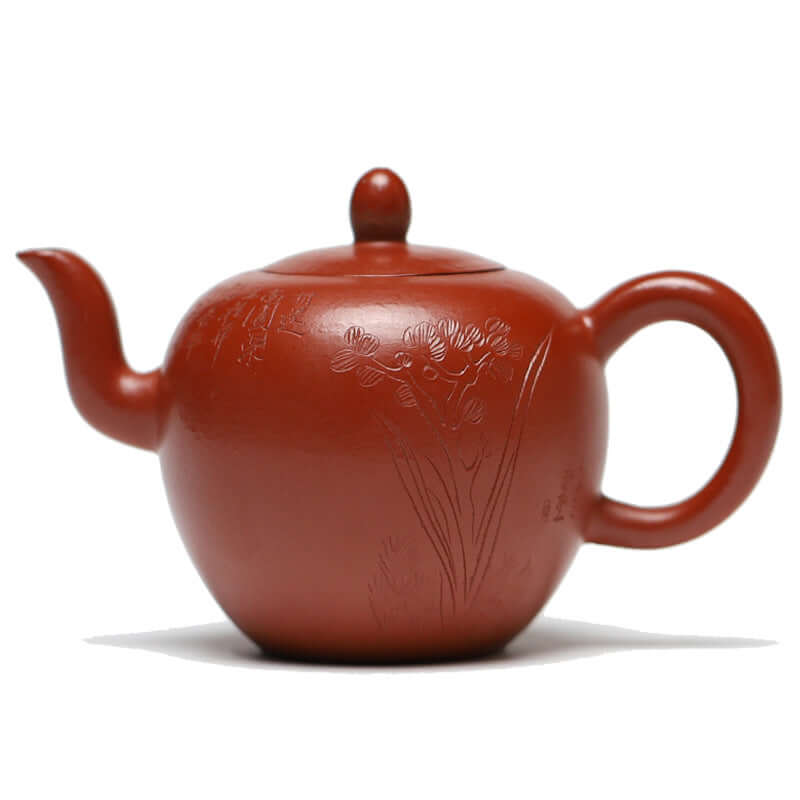 Handmade Yixing purple sand teapot with floral carving, showcasing a unique round design and smooth texture.