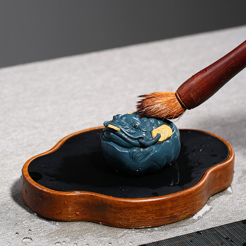 Handmade Yixing purple sand tea pet featuring a golden toad, ideal for tea ceremony decoration.