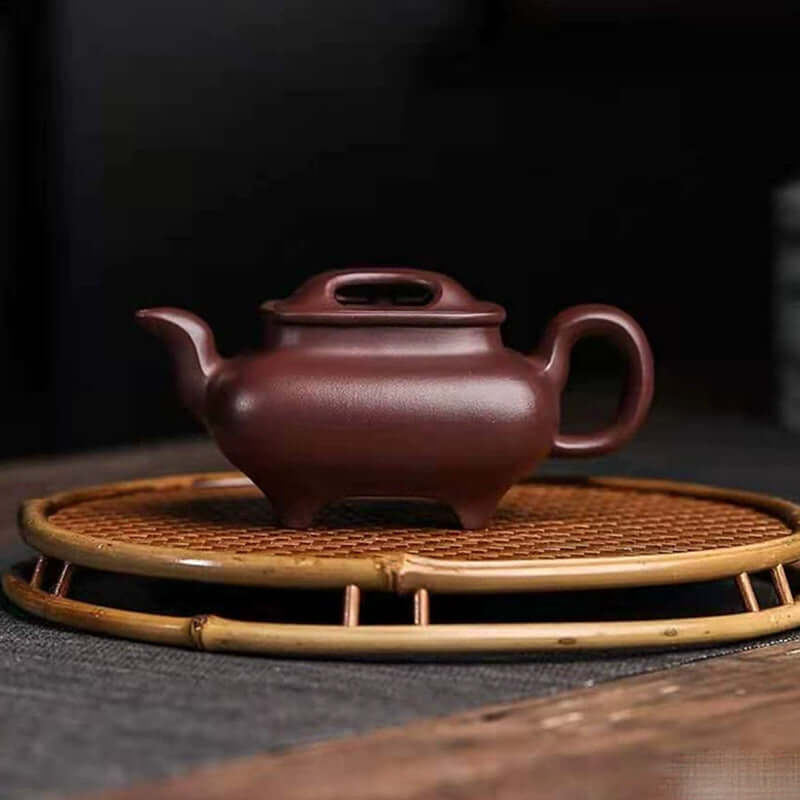 Handmade Yixing purple sand teapot on a bamboo tray, crafted by Yixing artisans with original mineral purple clay.