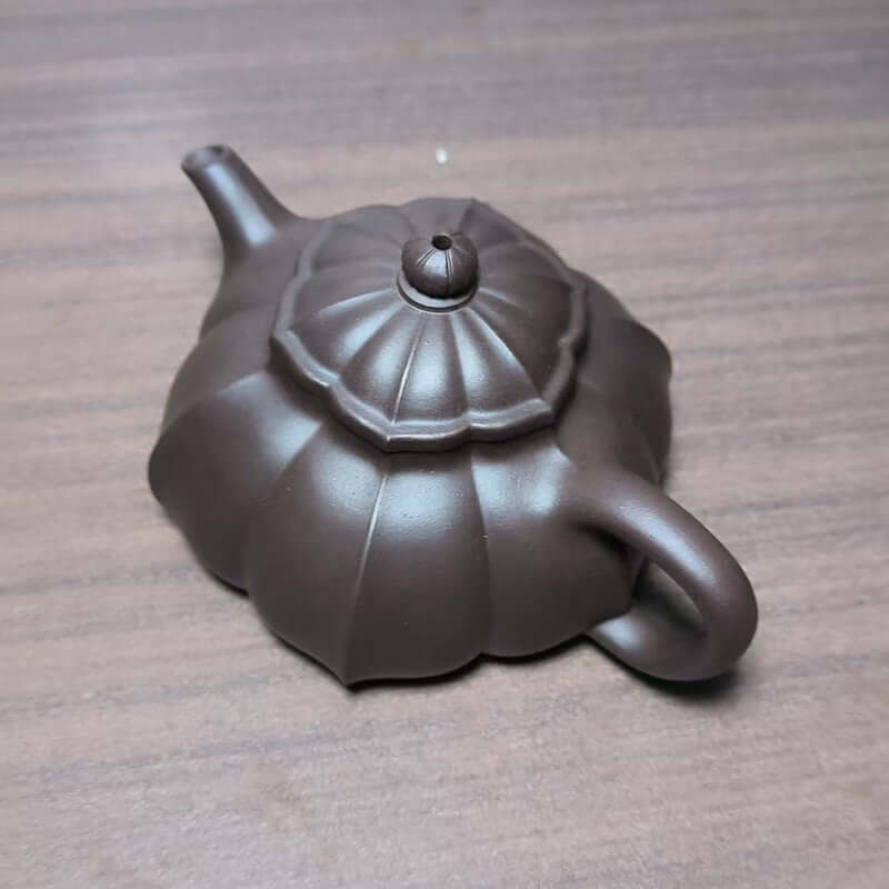 Handmade Yixing purple sand teapot with a unique flower design, crafted from original purple clay.