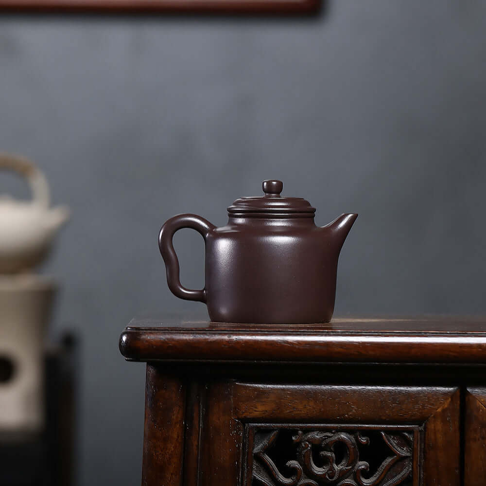 Handmade Yixing purple sand teapot on a wooden table, perfect for Kung Fu tea sessions.