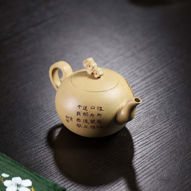 Handmade Yixing purple sand teapot with unique design and inscriptions, showcasing craftsmanship.