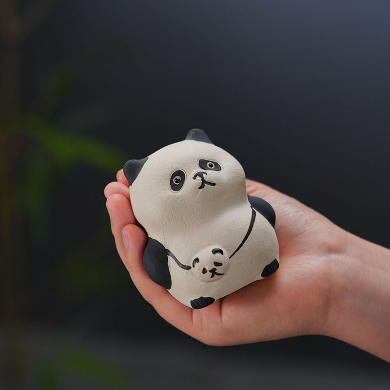 Handmade purple clay panda tea pet in hand, crafted by Yixing artisans, ideal for tea enthusiasts and collectors.
