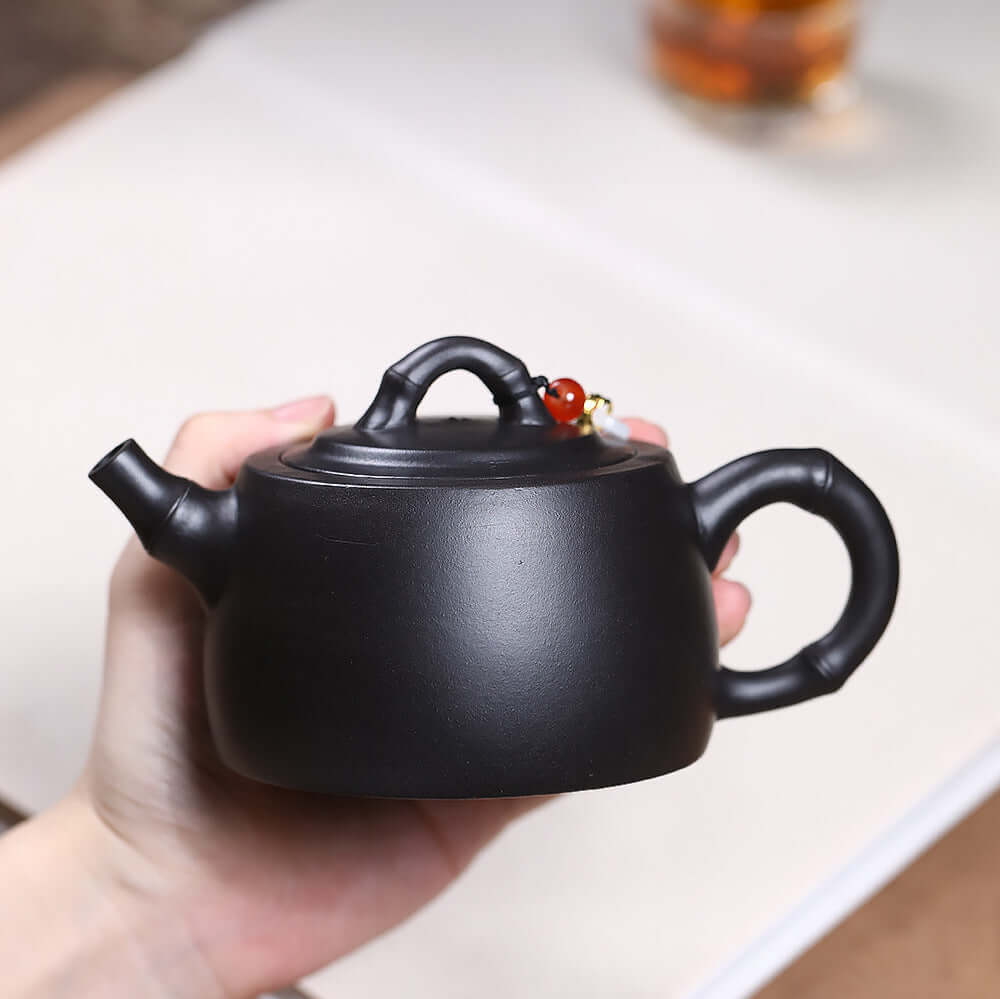 Handmade Yixing purple sand teapot in black, showcasing unique craftsmanship and perfect for Kung Fu tea sets.