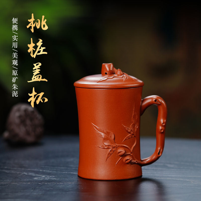 Handmade Yixing purple sand cup with lid, featuring intricate floral design, perfect for tea enthusiasts.
