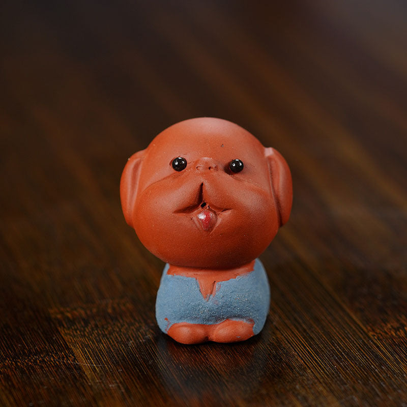 Handmade Yixing purple sand tea pet ornament, charming character sculpture, perfect for tea accessories.