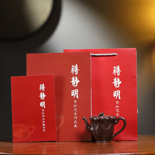 Handmade Yixing purple sand teapot with elegant red packaging, showcasing traditional craftsmanship and artistry.