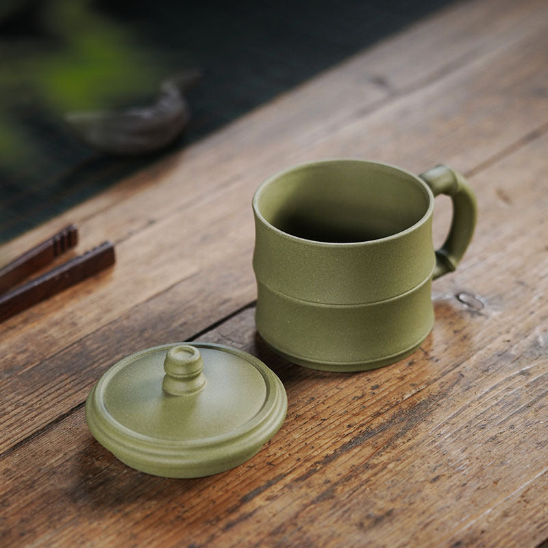 Handmade Yixing purple sand tea cup with bamboo section cover, designed for tea water separation and manual filtering.