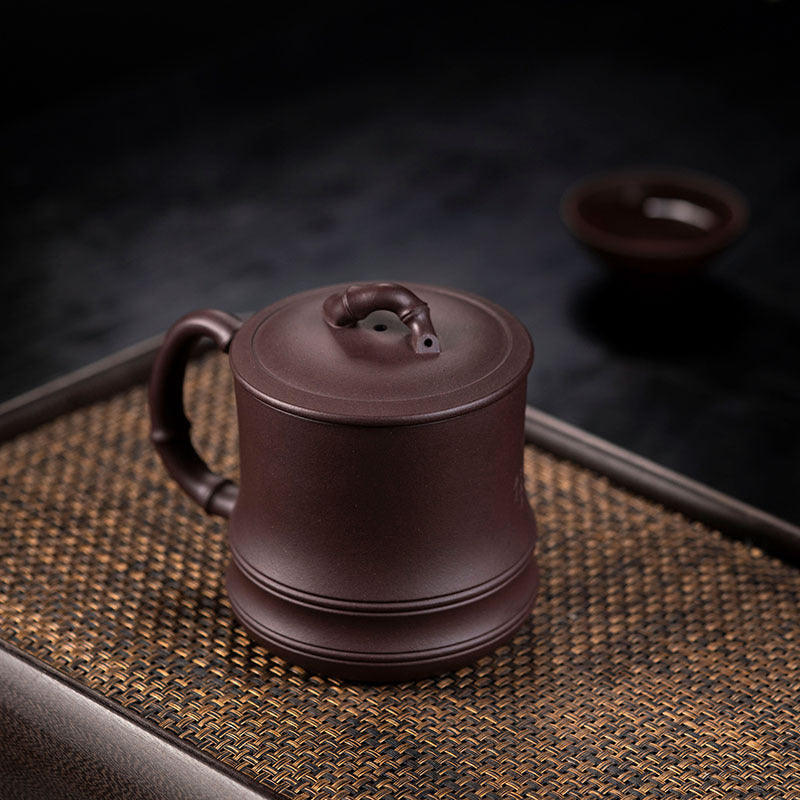 Handmade Yixing purple sand cup with bamboo cover, perfect for tea lovers and authentic craftsmanship.