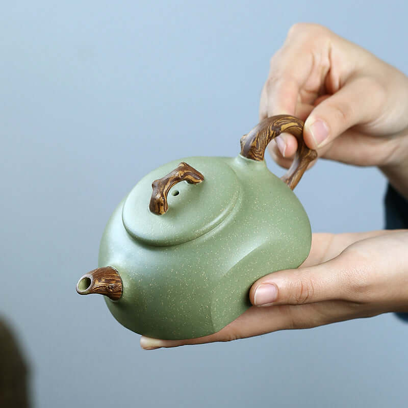 Handmade Yixing purple sand teapot with unique wooden handle, showcasing intricate design and craftsmanship.
