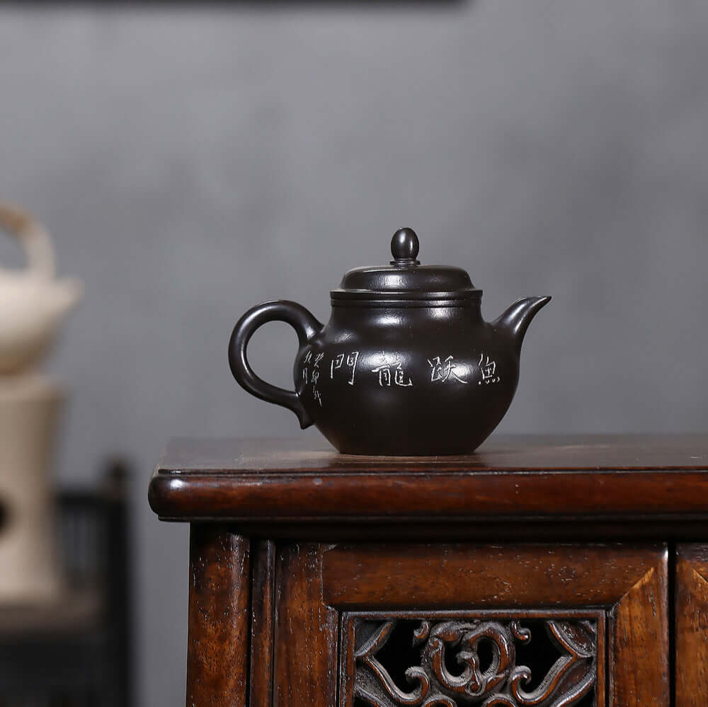 Handmade Yixing purple sand teapot featuring intricate engravings, perfect for Kung Fu tea sets.