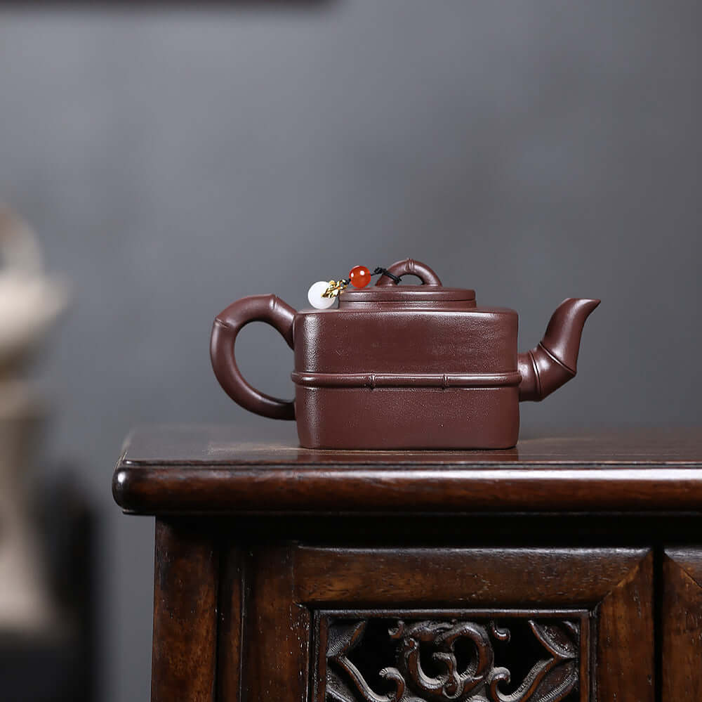 Handmade Yixing purple sand teapot showcasing original mineral aged clay craftsmanship on a wooden table.