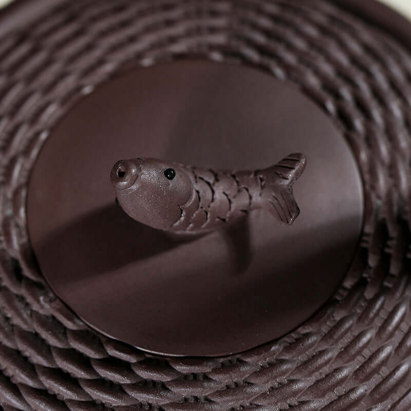 Handmade Yixing purple sand teapot lid featuring a detailed fish-shaped handle.