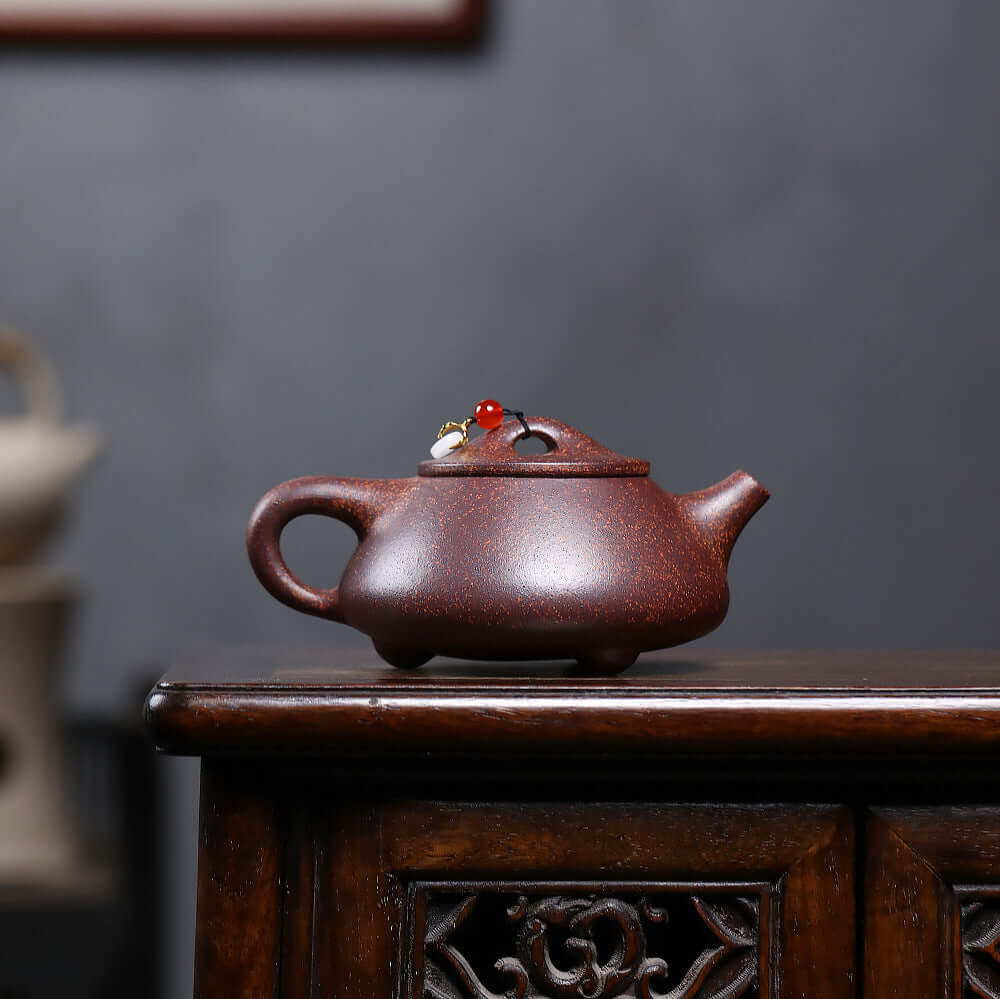 Handmade Yixing purple sand teapot with decorative scoop, perfect for Kung Fu tea sets and tea ceremonies.
