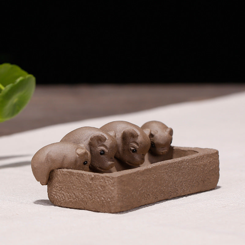 Four cute handmade purple sand piglet tea pets in a small bowl, perfect for tea ceremony accessories.