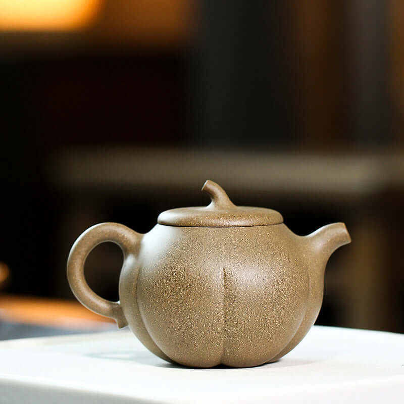 Handmade Yixing purple sand teapot in pumpkin shape, showcasing artisanal craftsmanship and traditional design.