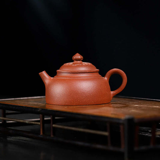 Handmade Yixing purple sand teapot on a wooden tray, showcasing original purple clay craftsmanship.